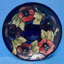A Moorcroft Cup and Saucer in the Pansy Pattern by William Moorcroft