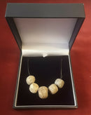 A Restrung Mammoth Bone, Five Beaded Pendant.