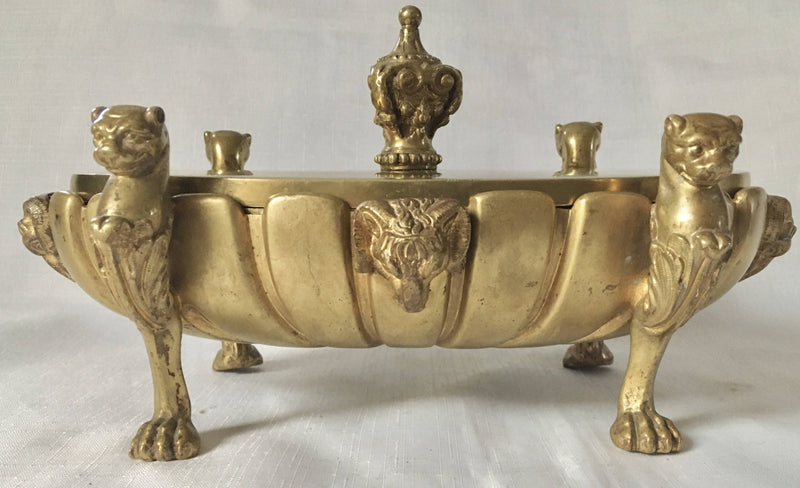 Regency period gilt bronze inkstand raised on lioness paw feet and adorned with ram masks.